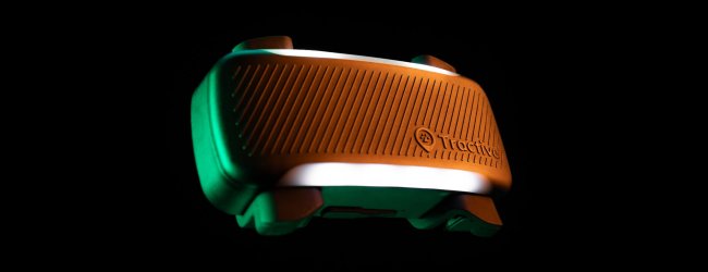 Primo piano del GPS Tractive con luce LED accesa su sfondo nero